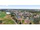 Aerial view of a residential community featuring a golf course and a pond at 1312 Patrick Pl, The Villages, FL 32162