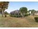 Exterior view of the screened in lanai in the backyard with tropical landscaping at 1312 Patrick Pl, The Villages, FL 32162