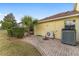 Paver patio with outdoor AC unit, shrubs, and palm tree at 1312 Patrick Pl, The Villages, FL 32162