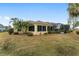 Inviting backyard featuring a screened-in porch, lush landscaping, and a well-maintained lawn at 1312 Patrick Pl, The Villages, FL 32162