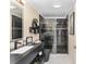 Modern bathroom featuring a black vanity with white sink, black toilet, and black and white glass shower at 1312 Patrick Pl, The Villages, FL 32162