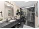 Modern bathroom featuring a black vanity with white sink, black toilet, and black and white glass shower at 1312 Patrick Pl, The Villages, FL 32162