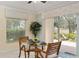 Bright dining area with a glass top table and a view of the landscaped backyard through sliding glass doors at 1312 Patrick Pl, The Villages, FL 32162