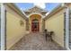 Inviting entryway with brick pavers, decorative accents, and a vibrant red front door with decorative glass at 1312 Patrick Pl, The Villages, FL 32162