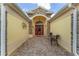 Inviting front entry features a brick-paved walkway, decorative stone accents, and a vibrant red door at 1312 Patrick Pl, The Villages, FL 32162