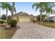 Charming front exterior with paver driveway, lush landscaping, and a well-maintained lawn, offering inviting curb appeal at 1312 Patrick Pl, The Villages, FL 32162