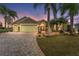 Beautiful front exterior with stone accents, paver driveway and tropical landscaping, showcasing its curb appeal at 1312 Patrick Pl, The Villages, FL 32162