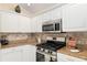 Kitchen featuring stainless steel appliances, granite countertops, white cabinets, and a decorative backsplash at 1312 Patrick Pl, The Villages, FL 32162