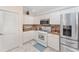 Cozy kitchen with white cabinets, granite countertops, stainless steel fridge and white oven at 1312 Patrick Pl, The Villages, FL 32162