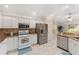 Spacious kitchen with white cabinets, stainless steel appliances, granite counters, and view to the dining area at 1312 Patrick Pl, The Villages, FL 32162