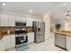 Open kitchen featuring stainless steel appliances, tile floors, stone backsplash, and granite countertops at 1312 Patrick Pl, The Villages, FL 32162
