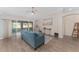 Bright living room with wood floors, ceiling fan, and sliding doors to a screened lanai at 1312 Patrick Pl, The Villages, FL 32162