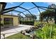 Screened patio with a serene rock water feature and lush landscaping, offering a peaceful outdoor retreat at 1312 Patrick Pl, The Villages, FL 32162