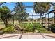 The screened-in patio overlooks a rock water feature, mature trees, and the expansive golf course at 1312 Patrick Pl, The Villages, FL 32162