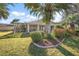 A lush backyard featuring a screened lanai, mature landscaping, and a well-manicured lawn at 1339 Florence Path, The Villages, FL 32162