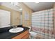 Bathroom features a flamingo shower curtain and a dark countertop with a white sink at 1339 Florence Path, The Villages, FL 32162