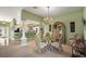 Elegant dining room with chandelier that flows into the kitchen, with a glass table and ornate chairs at 1339 Florence Path, The Villages, FL 32162