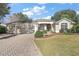 A well-maintained home featuring a three-car garage, landscaped front yard, and inviting entryway at 1339 Florence Path, The Villages, FL 32162