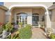 Inviting front porch with brick flooring, decorative plants, and a cozy seating area next to the front door at 1339 Florence Path, The Villages, FL 32162