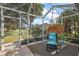 View of screened in lanai with seating area and lush greenery at 1339 Florence Path, The Villages, FL 32162