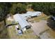 Aerial view of a ranch style home and horse property with shelters and metal roofs at 14100 Ne 46Th St, Silver Springs, FL 34488