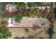 Aerial view of a property surrounded by trees, featuring a large parcel of land bordered by a red line at 14100 Ne 46Th St, Silver Springs, FL 34488