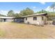 Exterior view of the home features a screened porch, well-maintained backyard, and outdoor seating at 14100 Ne 46Th St, Silver Springs, FL 34488