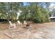 An inviting outdoor seating area with a stone fire pit and rocking chairs, perfect for relaxing evenings at 14100 Ne 46Th St, Silver Springs, FL 34488