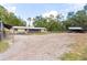 Sand ground lot featuring horse shelters, outbuildings, mature trees and the house at the back at 14100 Ne 46Th St, Silver Springs, FL 34488