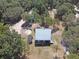 An aerial view reveals a home with metal roof, outbuildings, and circular drive at 14415 County Road 448, Tavares, FL 32778