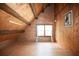 Spacious attic room showcasing wood beams and ample natural light from the window at 14415 County Road 448, Tavares, FL 32778