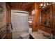 Cozy bathroom featuring wood paneling, tub with shower, vanity, and ample storage space at 14415 County Road 448, Tavares, FL 32778