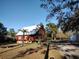 Inviting log cabin showcasing a well-maintained lawn and a detached garage, creating a serene setting at 14415 County Road 448, Tavares, FL 32778