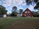 Exterior view of the home, showing the lawn, garden, metal garage and house at 14415 County Road 448, Tavares, FL 32778