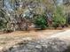 A partial exterior view of the home framed by mature trees and landscape at 14415 County Road 448, Tavares, FL 32778