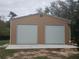 A metal garage with two bay doors provides ample storage and workspace on the property at 14415 County Road 448, Tavares, FL 32778