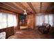 Comfortable living room with wood paneled walls and hardwood floors, with TV and armchair at 14415 County Road 448, Tavares, FL 32778