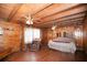 Cozy main bedroom showcasing wood-paneled walls, hardwood floors, and comfortable furnishings for a relaxing retreat at 14415 County Road 448, Tavares, FL 32778