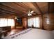 Spacious main bedroom featuring wood-paneled walls, hardwood floors, ample natural light, and a relaxing atmosphere at 14415 County Road 448, Tavares, FL 32778