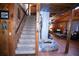 Hallway with staircase leading to an inviting living room with stone fireplace at 14415 County Road 448, Tavares, FL 32778