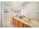 Bathroom with a double sink vanity, decorative mirrors, and a shower at 14842 Cedar Branch Way, Orlando, FL 32824