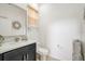 Stylish half bathroom with a modern vanity, decorative mirror, and neutral tones at 14842 Cedar Branch Way, Orlando, FL 32824