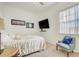 Bedroom featuring a wall mounted TV, accent chairs, and bright light at 14842 Cedar Branch Way, Orlando, FL 32824