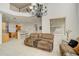 Open-concept living room with a view of the second-floor balcony, chandelier, and seating at 14842 Cedar Branch Way, Orlando, FL 32824