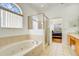 Well-lit main bathroom featuring a garden tub, walk-in shower, and access to the main bedroom at 14842 Cedar Branch Way, Orlando, FL 32824