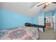 Cozy bedroom features vibrant blue walls, carpet and ceiling fan at 16705 Rolling Green Dr, Clermont, FL 34714