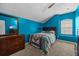 Bedroom featuring blue walls, carpet, a window and a dresser with a TV at 16705 Rolling Green Dr, Clermont, FL 34714