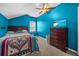 Bedroom featuring blue walls, carpet, a window and a dresser with a TV at 16705 Rolling Green Dr, Clermont, FL 34714