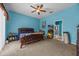 Bright bedroom featuring blue walls, a ceiling fan, and a comfortable bed at 16705 Rolling Green Dr, Clermont, FL 34714