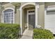 Inviting front entrance with a well-manicured lawn, arched entryway, and charming flower pot decor at 16705 Rolling Green Dr, Clermont, FL 34714